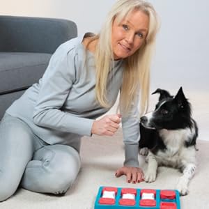 Nina Ottosson teaching her dog how to play with a dog puzzle.